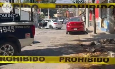 Calle acordonada, y al fondo auto en el que viajaba un hombre que fue atacado a balazos