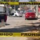 Calle acordonada, y al fondo auto en el que viajaba un hombre que fue atacado a balazos