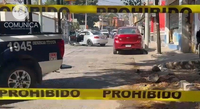 Calle acordonada, y al fondo auto en el que viajaba un hombre que fue atacado a balazos