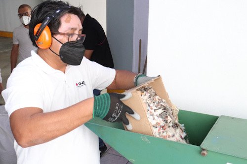 Persona con credenciales de elector trituradas por el INE