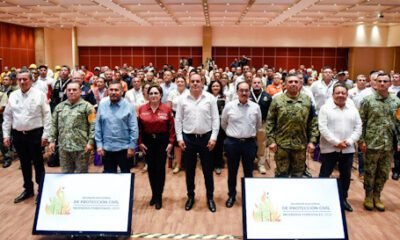 Varias personas paradas en la reunión nacional de PC