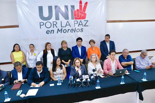 Integrantes de partidos políticos y Lucy Meza sentados en una mesa de trabajo por la seguridad