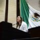 Diputada en tribuna con la bandera de fondo