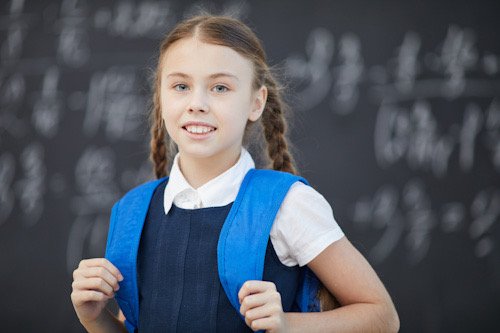 Niña con trenzas y una mochila color azul