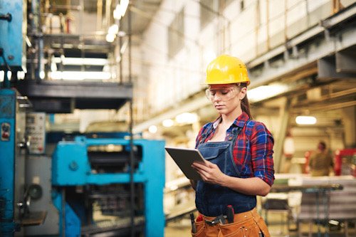 Mujer con un casco en un espacio de trabajo en una empresa