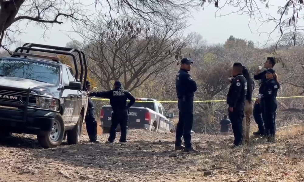 policías en un camino de terracería y una patrulla, en el lugar encontraron 3 cuerpos