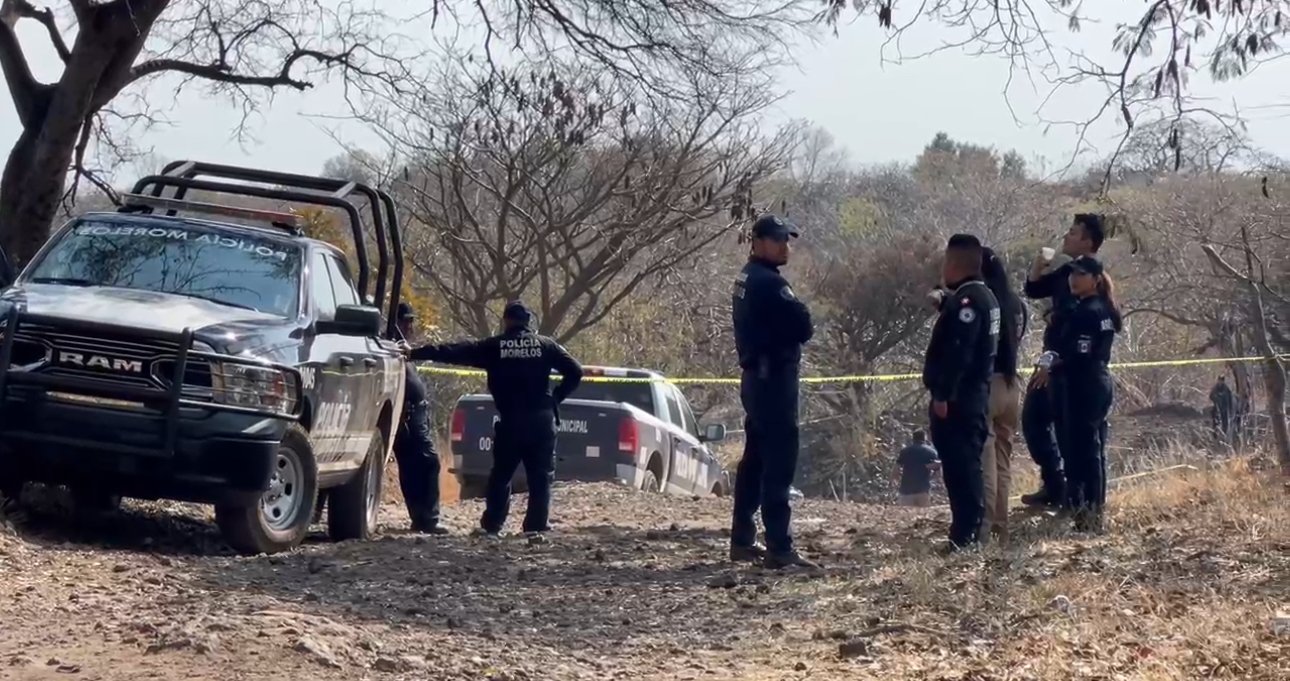 policías en un camino de terracería y una patrulla, en el lugar encontraron 3 cuerpos