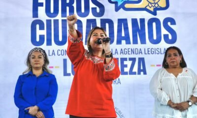 Senadora Lucy Meza de pie con la mano levantada en Foros Ciudadanos