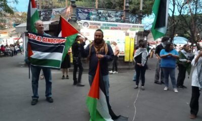 Hombres con banderas encabezando una marcha para pedir paz en Gaza