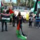 Hombres con banderas encabezando una marcha para pedir paz en Gaza