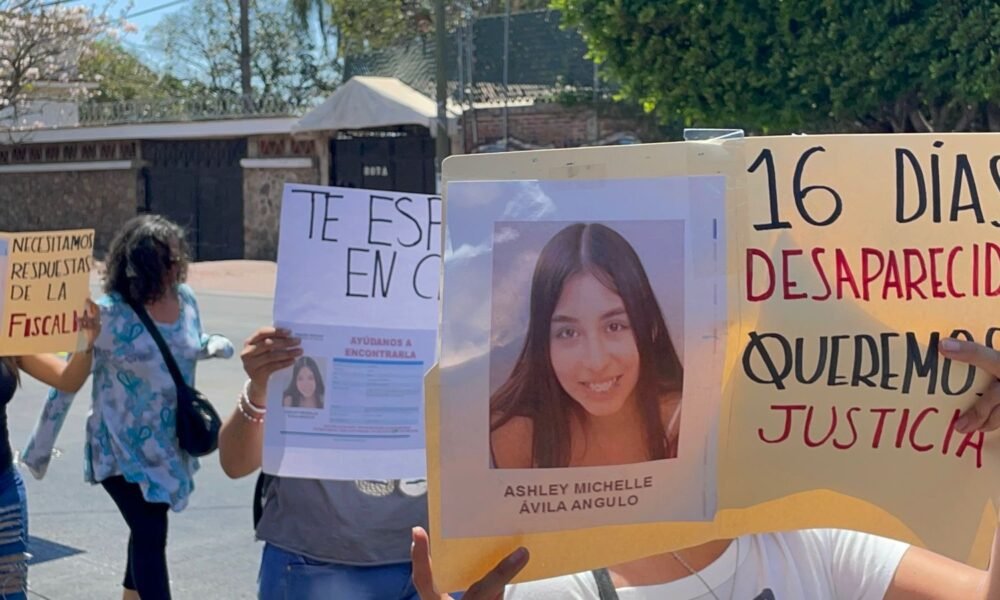Cartulina con el rostro de una menor desaparecida y personas que caminan por la calle