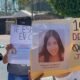 Cartulina con el rostro de una menor desaparecida y personas que caminan por la calle