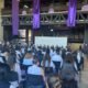 Autoridades universitarias sentadas en una mesa, con muchas mujeres de invitadas