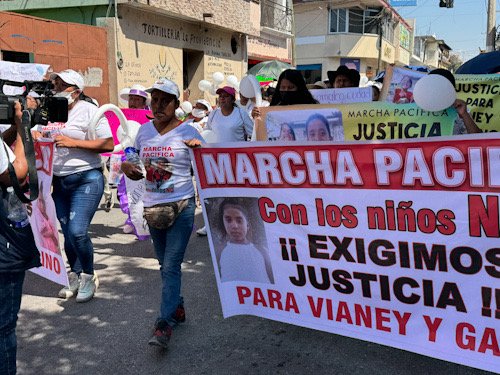 Pancartas para pedir justicia por Vianey y Gabino, muchas personas caminando con playeras blancas