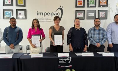 Autoridades el IMPEPAC con un documento en la mano en la firma de un convenio