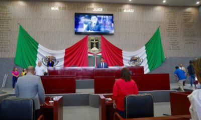 Dos banderas de México y diputados en una sesión del Congreso