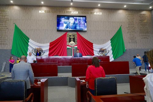 Dos banderas de México y diputados en una sesión del Congreso