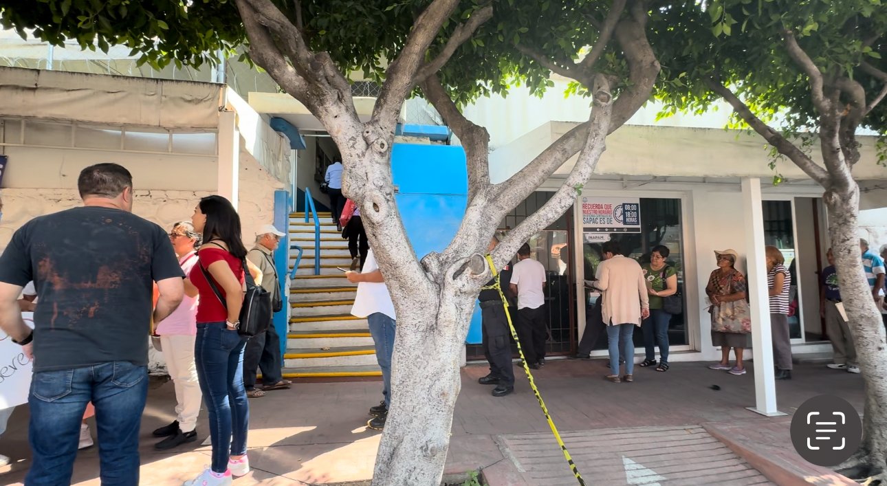 Varias personas reunidas afuera de las oficinas del Sapac, se manifiestan por falta de agua