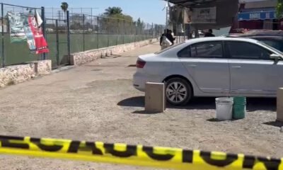 Cancha de fútbol, un auto blanco y una cinta acordonando la zona