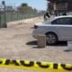 Cancha de fútbol, un auto blanco y una cinta acordonando la zona