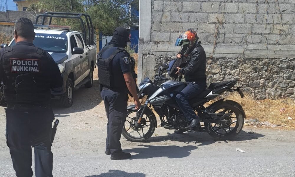 Tres policías revisando una motocicleta y al conductor