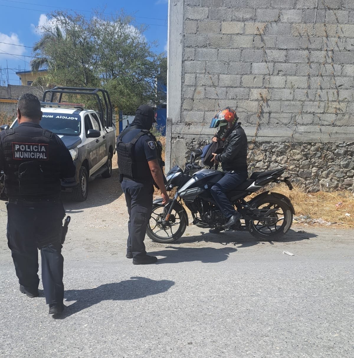 Tres policías revisando una motocicleta y al conductor