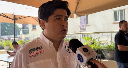 Un hombre con una camisa blanca y a un costado el nombre de Jonathan Márquez