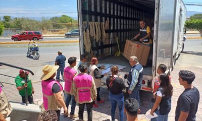 Varias personas bajando cajas de un camión