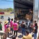 Varias personas bajando cajas de un camión