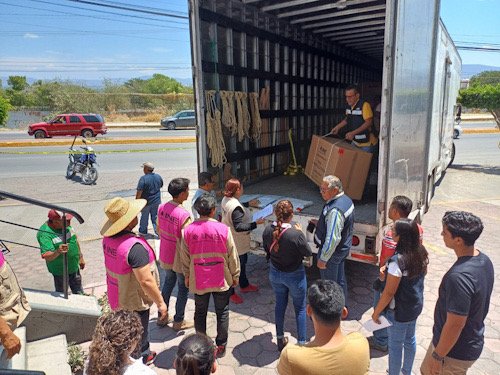 Varias personas bajando cajas de un camión