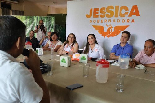 mujeres y hombres reunidos sentados en una mesa