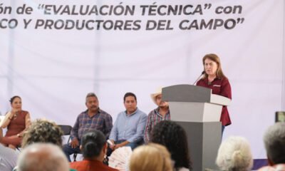 Mujer con camisa gilda parada frente a un micrófono