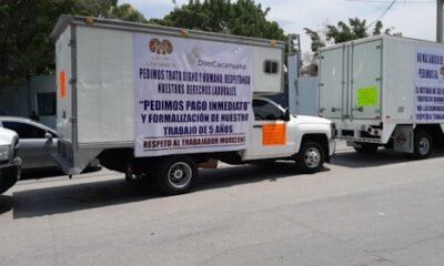 Camiones con mantas en demanda de pago a trabajadores