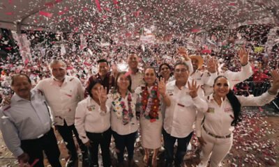 varias personas en una plaza con muchos papeles y levantando las manos