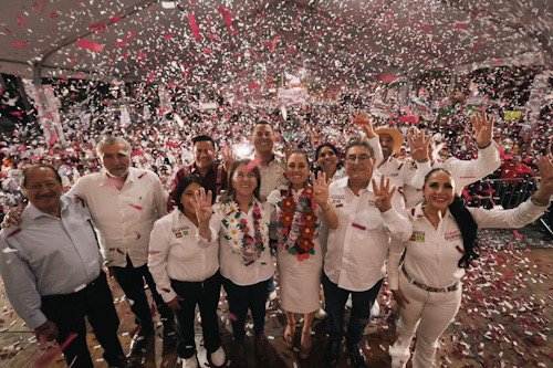 varias personas en una plaza con muchos papeles y levantando las manos