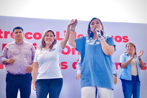 Dos mujeres tomadas de la mano levantando en señal de victoria