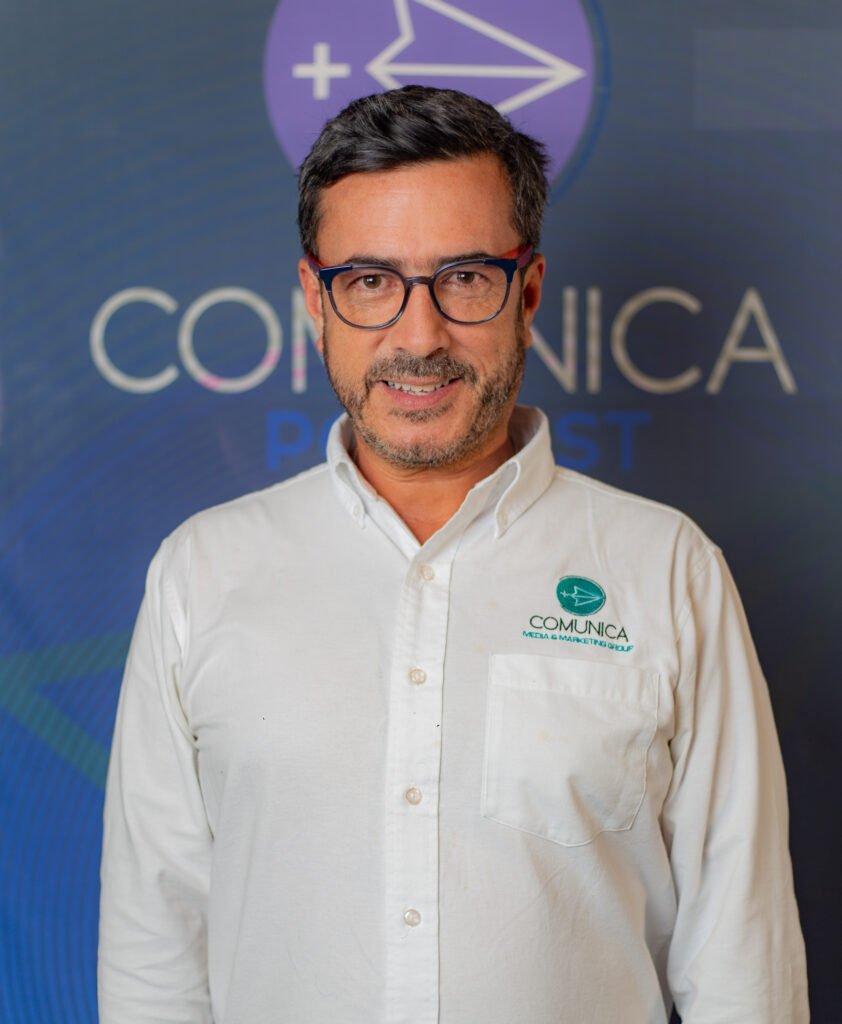 hombre con camisa blanca y lentes, socio fundador y director general de comunica mas media